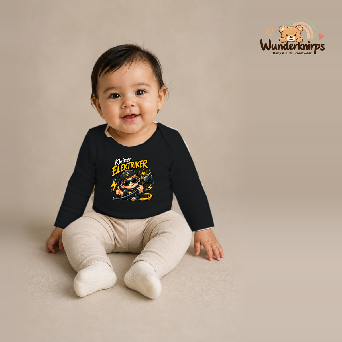 Babybody für Mädchen in Schwarz mit Motiv „Kleiner Elektriker“, getragen von einem Kind – Wunderknirps.