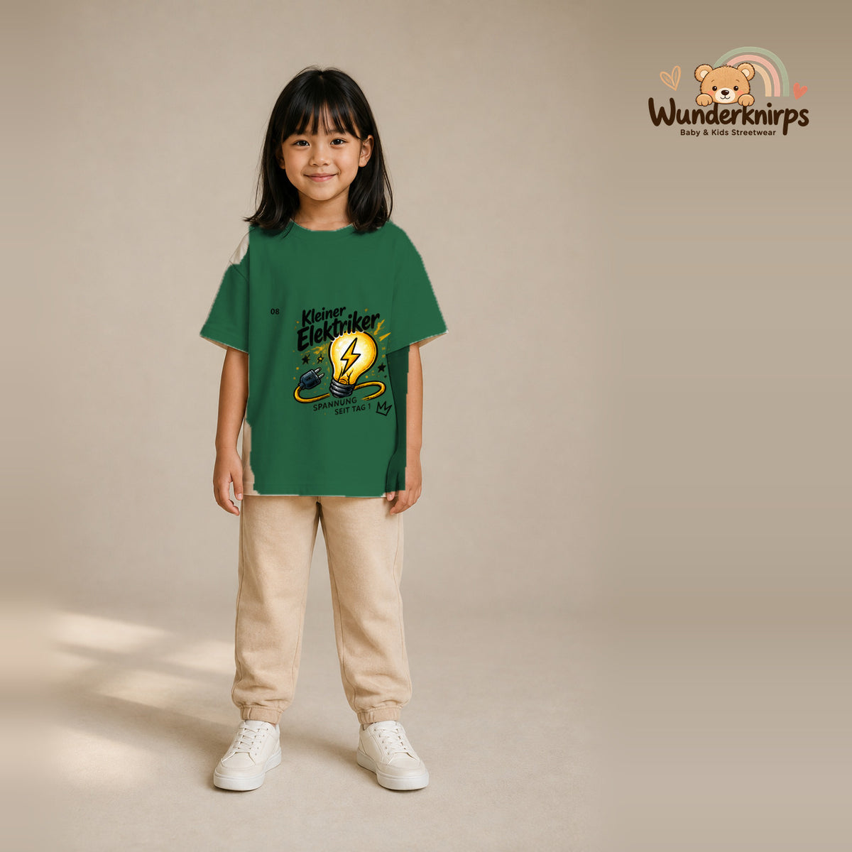 T-Shirt für Mädchen in Grün mit Motiv „Kleiner Elektriker“, getragen von einem Kind – Wunderknirps.
