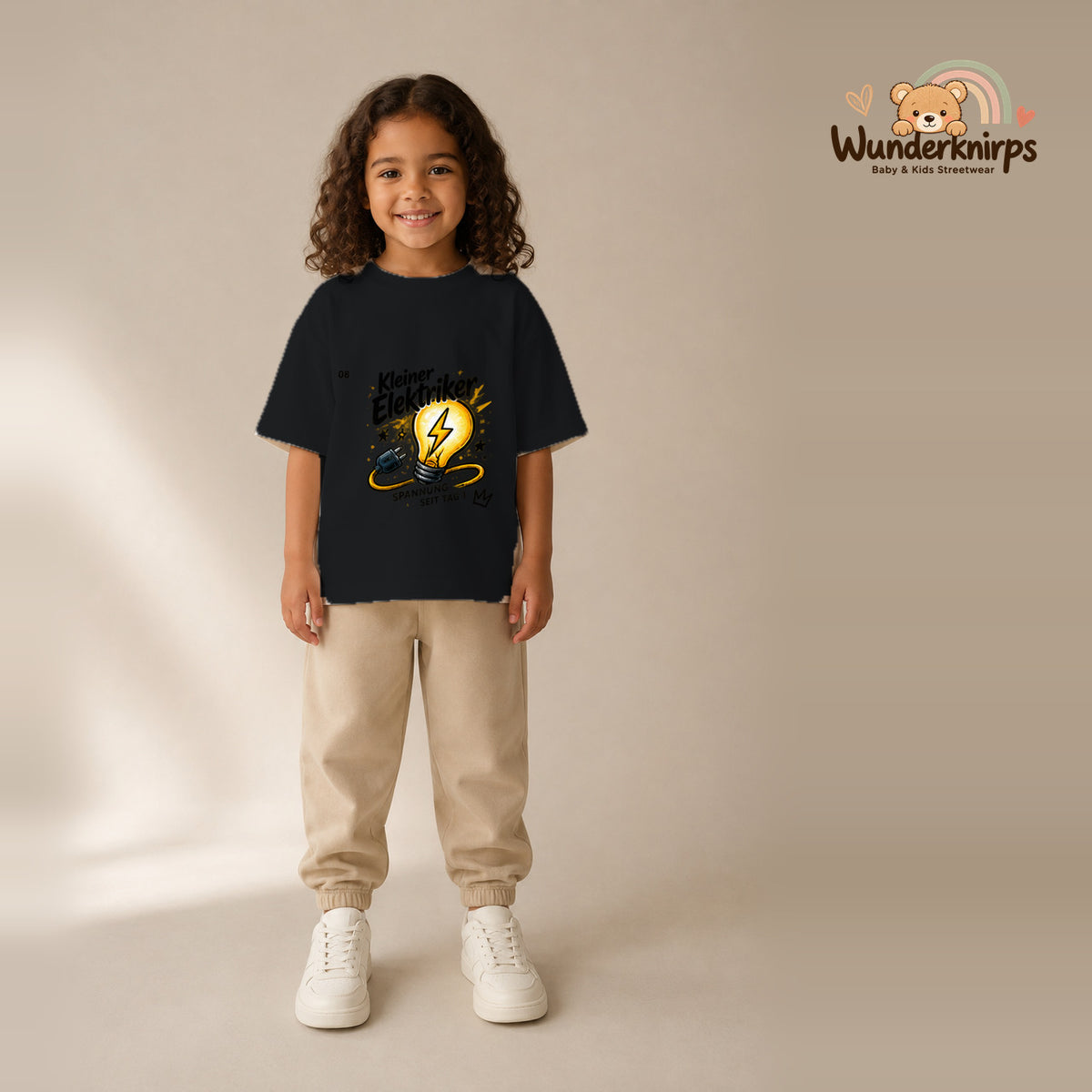 T-Shirt für Mädchen in Schwarz mit Motiv „Kleiner Elektriker“, getragen von einem Kind – Wunderknirps.