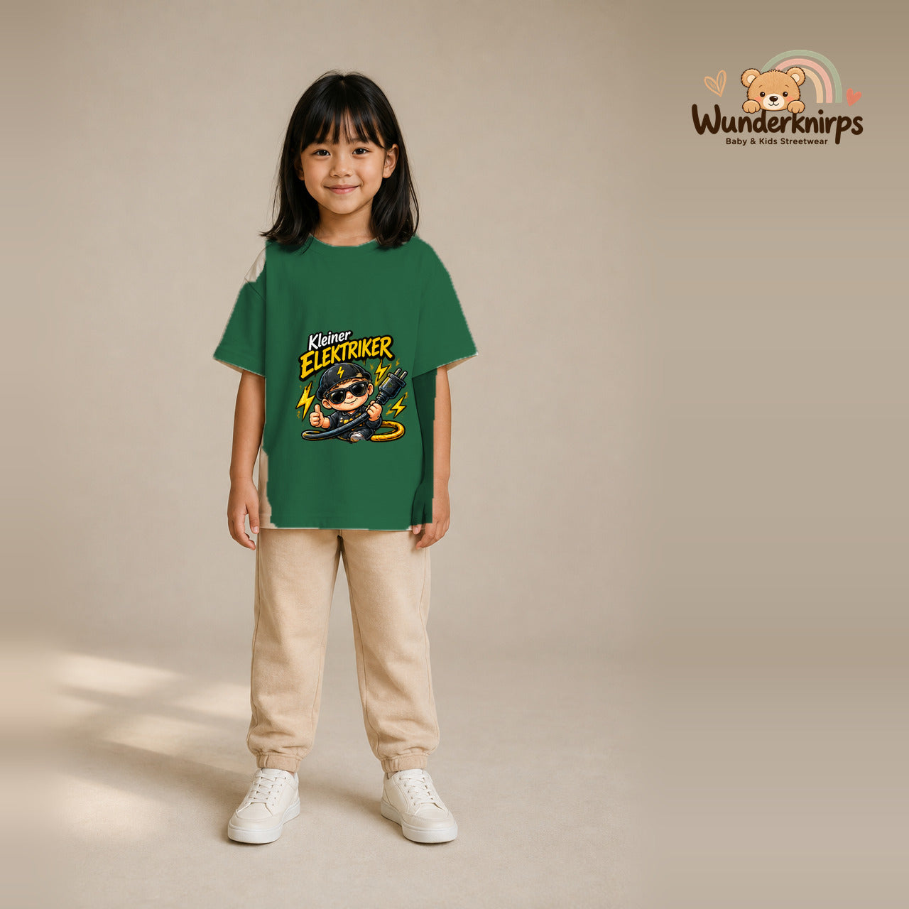 T-Shirt für Mädchen in Grün mit Motiv „Kleiner Elektriker“, getragen von einem Kind – Wunderknirps.
