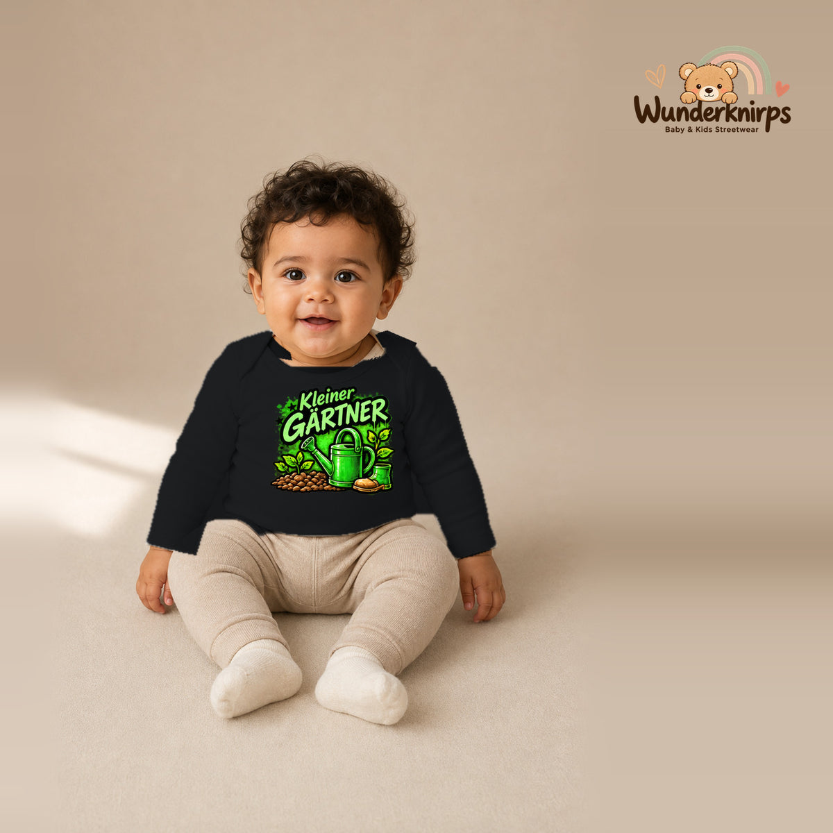 Babybody für Jungen in Schwarz mit Motiv „Kleiner Gärtner“, getragen von einem Kind – Wunderknirps.