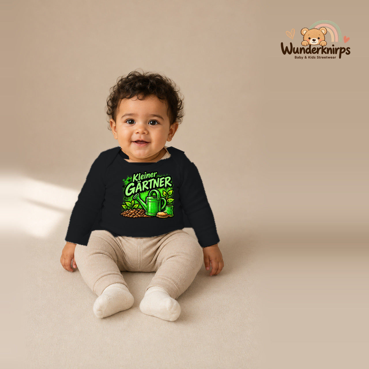 Babybody für Jungen in Schwarz mit Motiv „Kleiner Gärtner“, getragen von einem Kind – Wunderknirps.