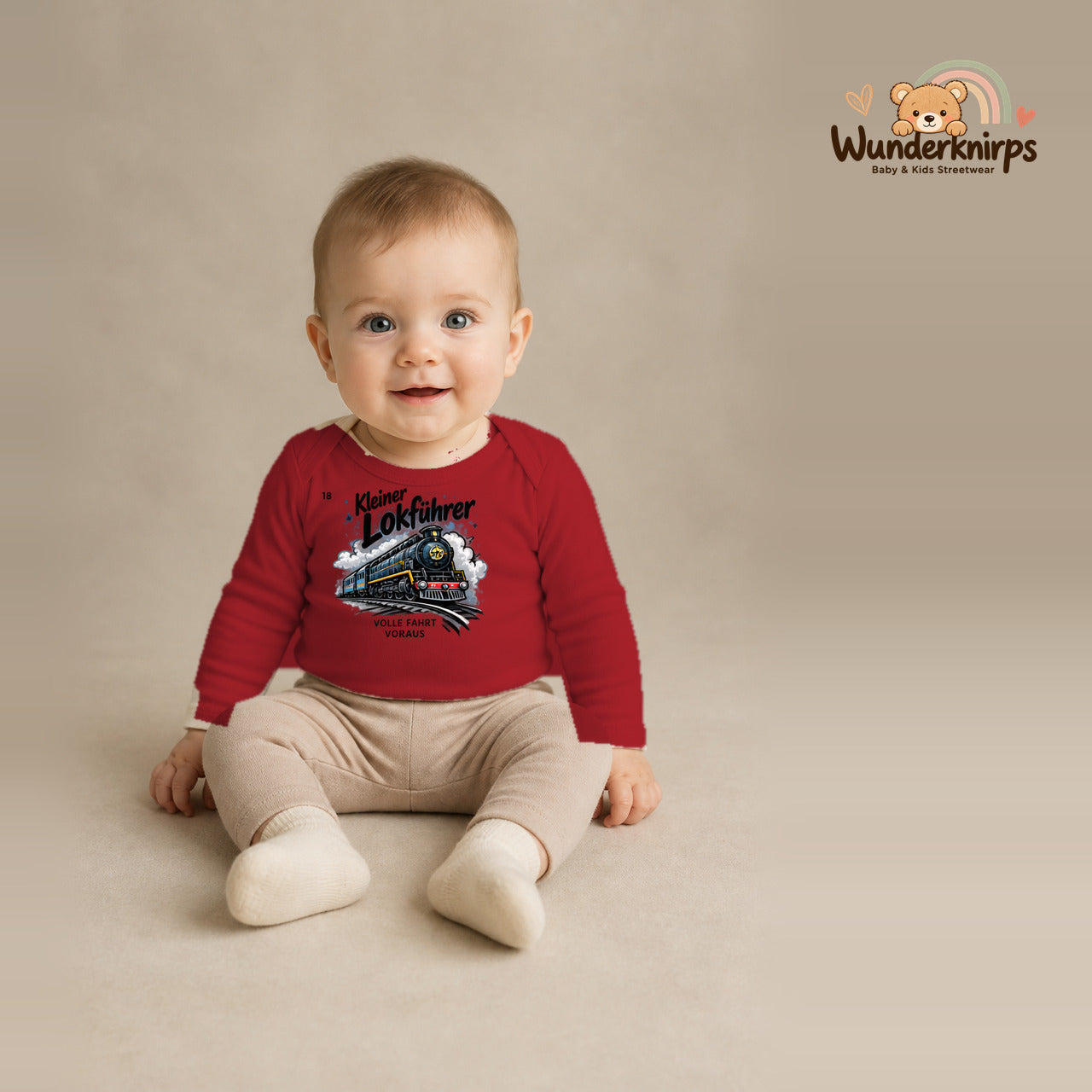 Babybody für Jungen in Rot mit Motiv „Kleiner Lokführer“, getragen von einem Kind – Wunderknirps.