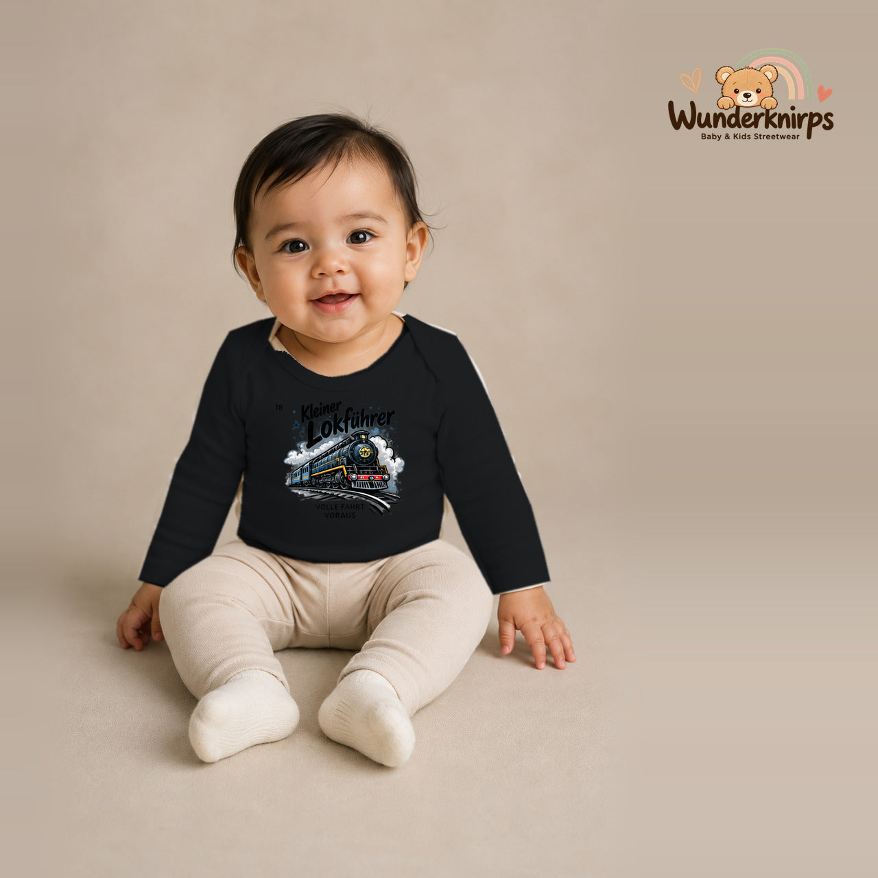 Babybody für Mädchen in Schwarz mit Motiv „Kleiner Lokführer“, getragen von einem Kind – Wunderknirps.