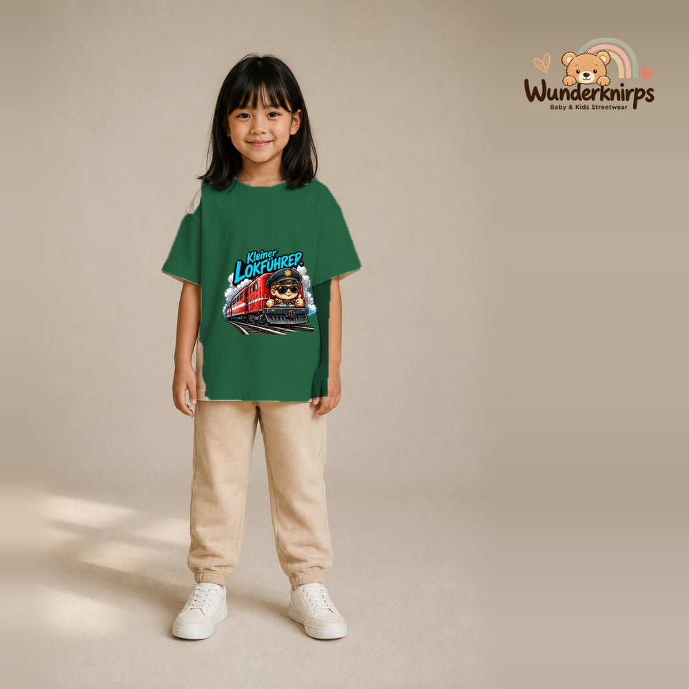 T-Shirt für Mädchen in Grün mit Motiv „Kleiner Lokführer“, getragen von einem Kind – Wunderknirps.