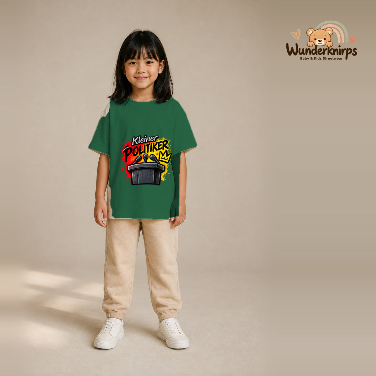 T-Shirt für Mädchen in Grün mit Motiv „Kleiner Politiker“, getragen von einem Kind – Wunderknirps.