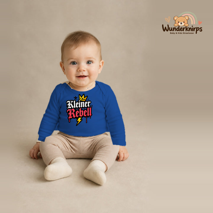 Babybody für Jungen in Blau mit Motiv „Kleiner Rebell“, getragen von einem Kind – Wunderknirps.