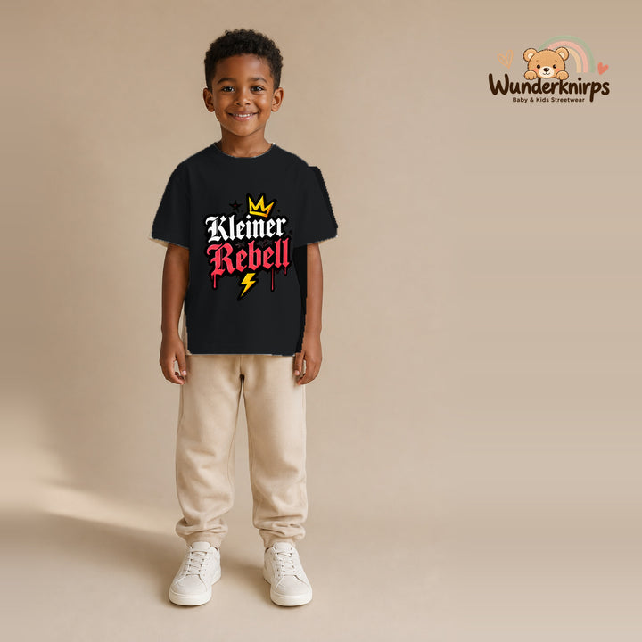 T-Shirt für Jungen in Schwarz mit Motiv „Kleiner Rebell“, getragen von einem Kind – Wunderknirps.