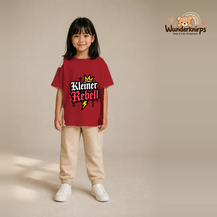 T-Shirt für Mädchen in Rot mit Motiv „Kleiner Rebell“, getragen von einem Kind – Wunderknirps.