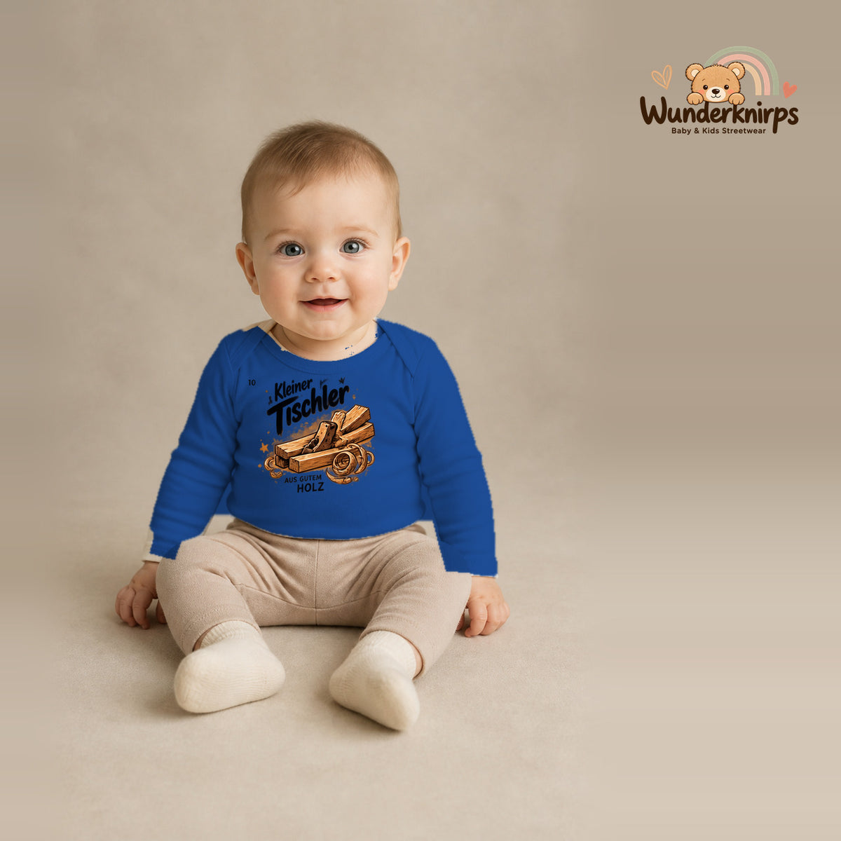 Babybody für Jungen in Blau mit Motiv „Kleiner Tischler“, getragen von einem Kind – Wunderknirps.