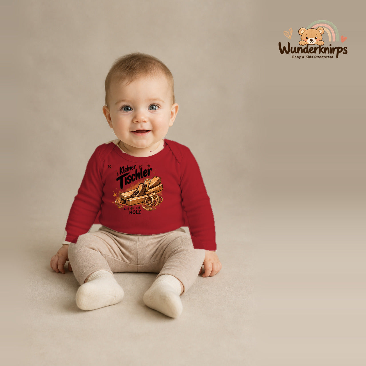 Babybody für Jungen in Rot mit Motiv „Kleiner Tischler“, getragen von einem Kind – Wunderknirps.