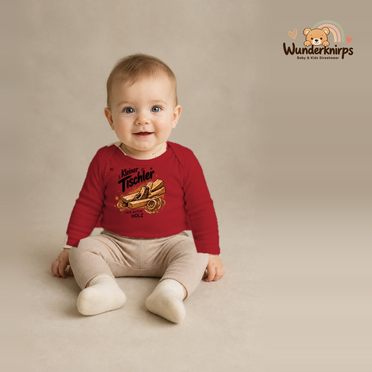 Babybody für Jungen in Rot mit Motiv „Kleiner Tischler“, getragen von einem Kind – Wunderknirps.