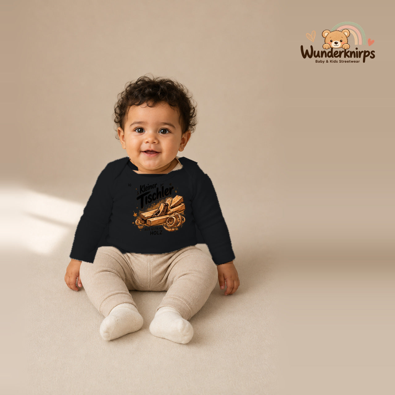 Babybody für Jungen in Schwarz mit Motiv „Kleiner Tischler“, getragen von einem Kind – Wunderknirps.