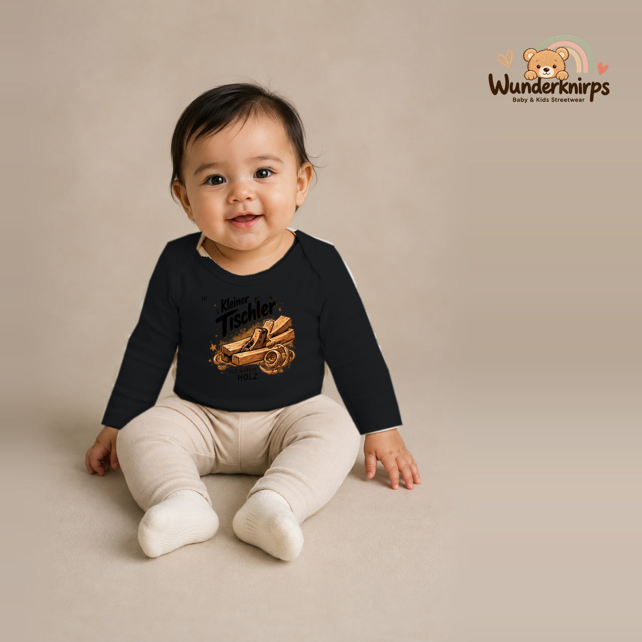 Babybody für Mädchen in Schwarz mit Motiv „Kleiner Tischler“, getragen von einem Kind – Wunderknirps.
