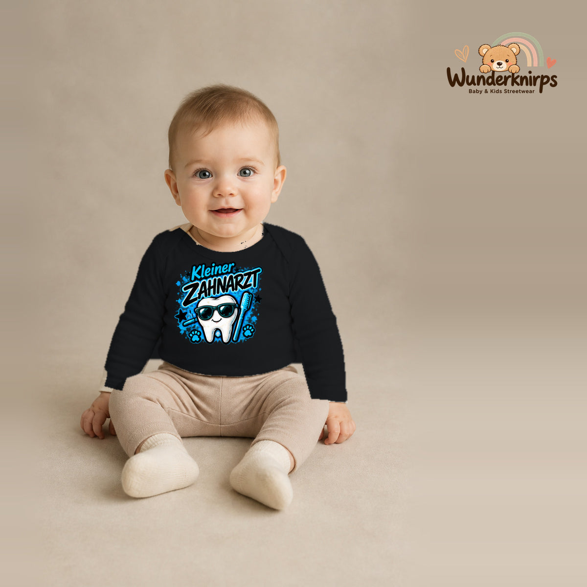 Babybody für Jungen in Schwarz mit Motiv „Kleiner Zahnarzt“, getragen von einem Kind – Wunderknirps.