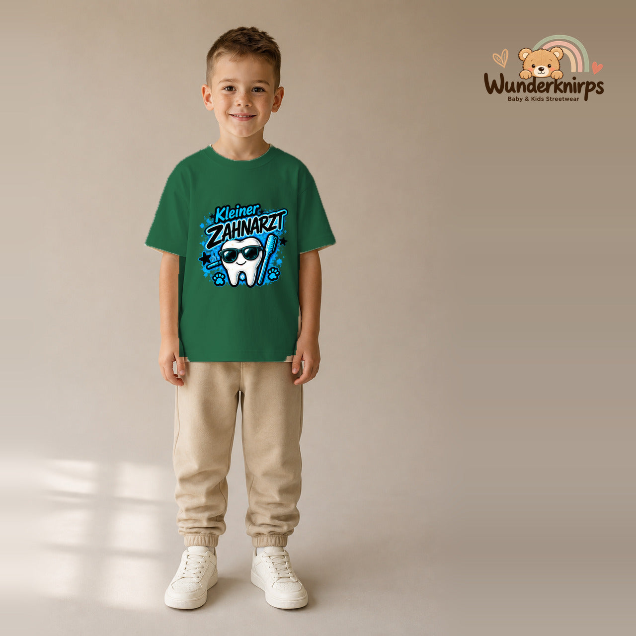 T-Shirt für Jungen in Grün mit Motiv „Kleiner Zahnarzt“, getragen von einem Kind – Wunderknirps.