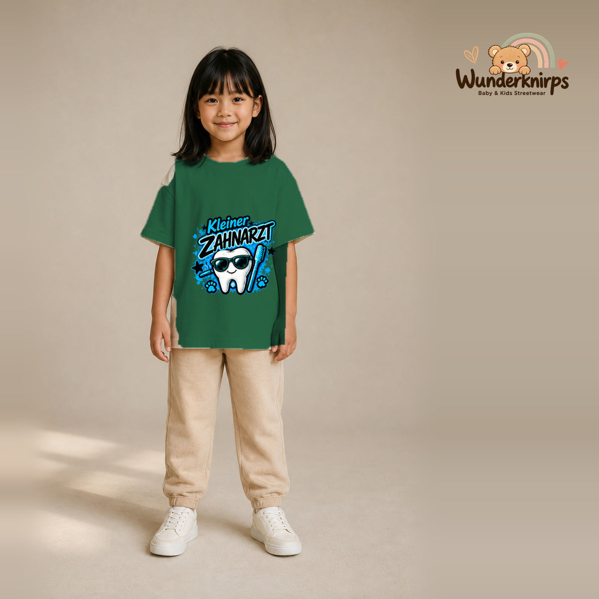 T-Shirt für Mädchen in Grün mit Motiv „Kleiner Zahnarzt“, getragen von einem Kind – Wunderknirps.