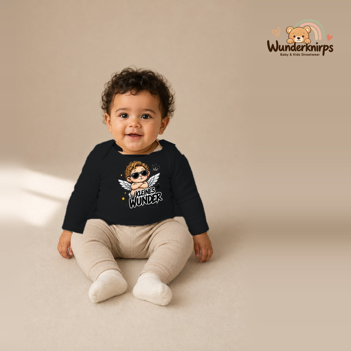 Babybody für Jungen in Schwarz mit Motiv „Kleines Wunder“, getragen von einem Kind – Wunderknirps.