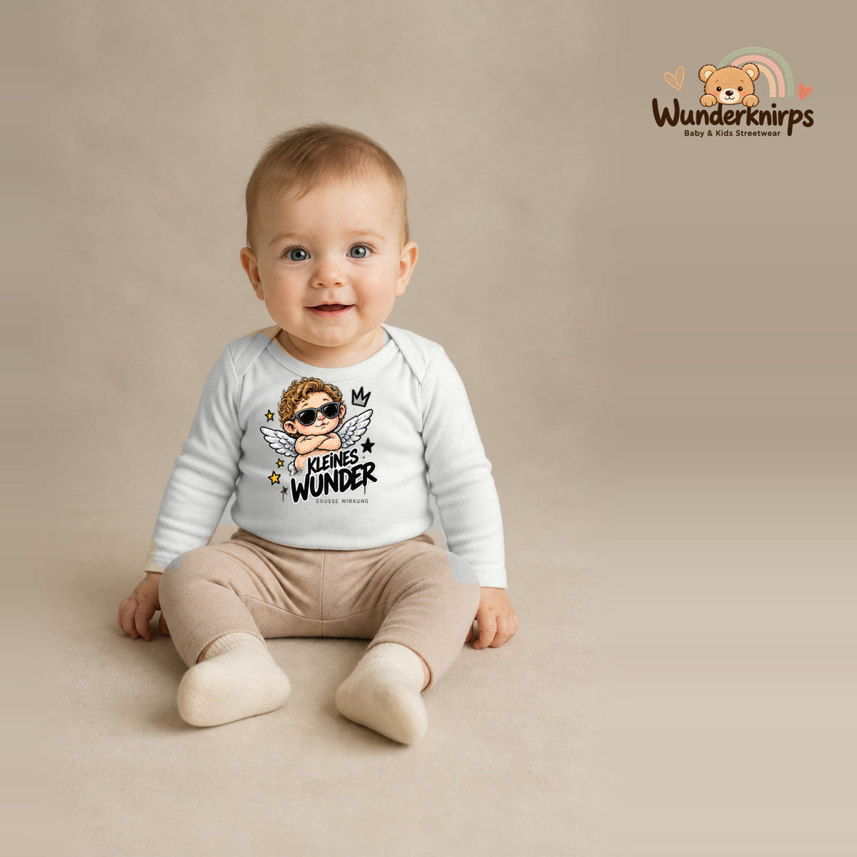 Babybody für Jungen in Weiß mit Motiv „Kleines Wunder“, getragen von einem Kind – Wunderknirps.