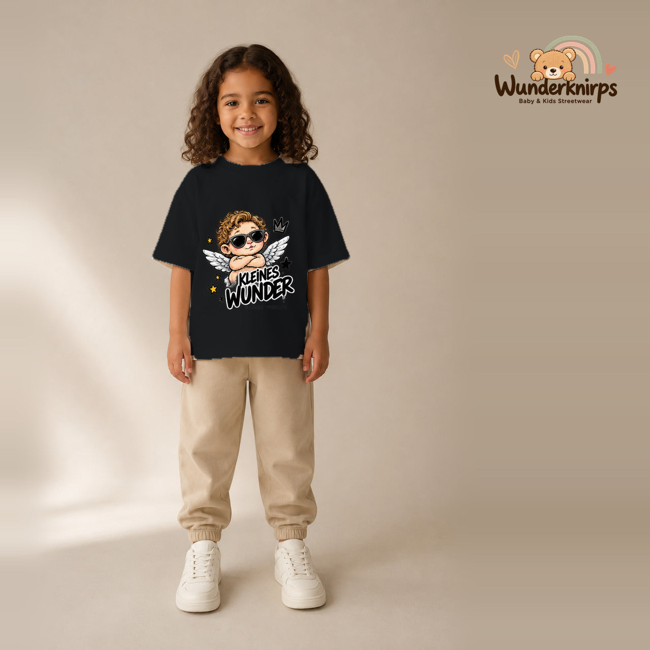 T-Shirt für Mädchen in Schwarz mit Motiv „Kleines Wunder“, getragen von einem Kind – Wunderknirps.