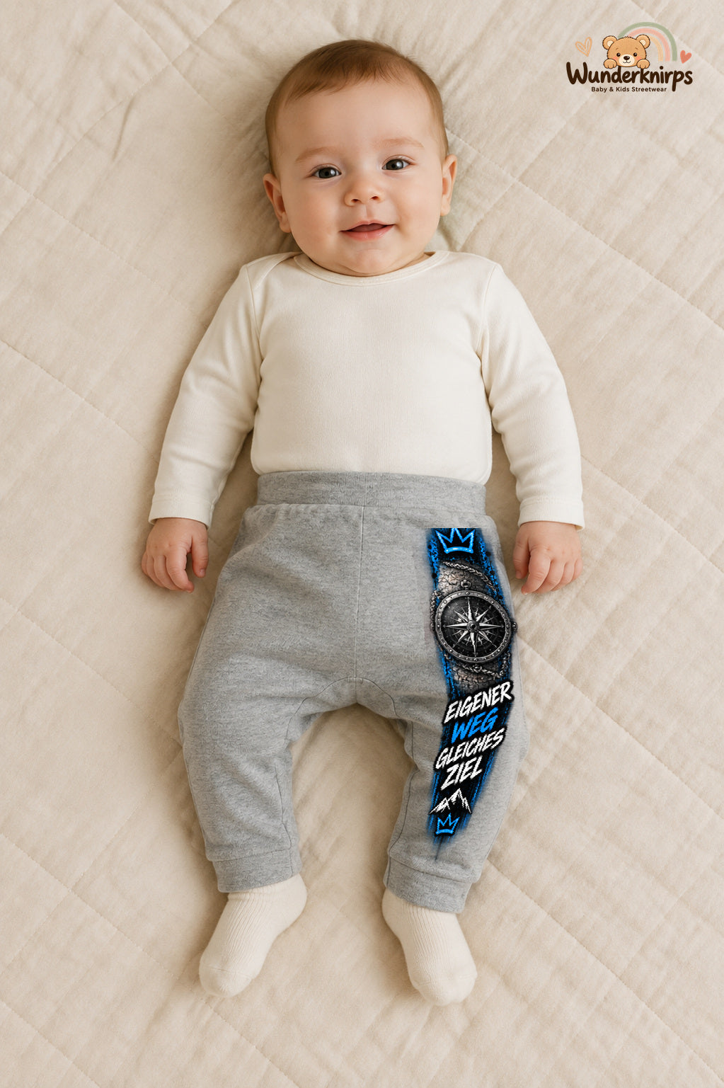 Kompass Alltagsheld – Eigener weg gleiches ziel – Babyhose für Jungen: Grau meliert mit Kompass-Druck am Hosenbein – Wunderknirps.