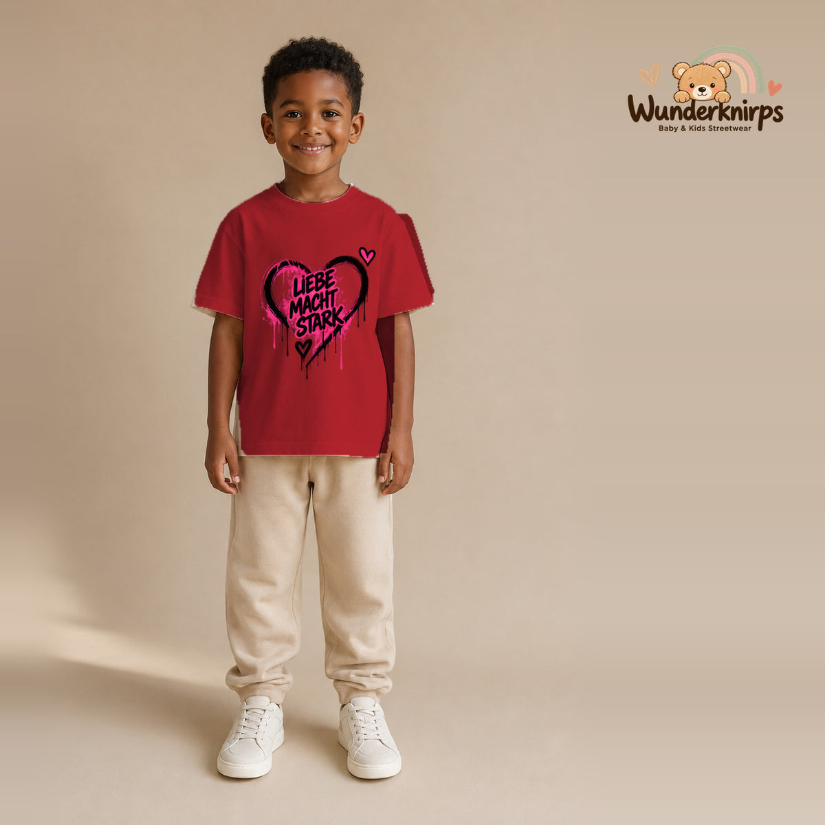 T-Shirt für Jungen in Rot mit Motiv „Liebe macht stark“, getragen von einem Kind – Wunderknirps.
