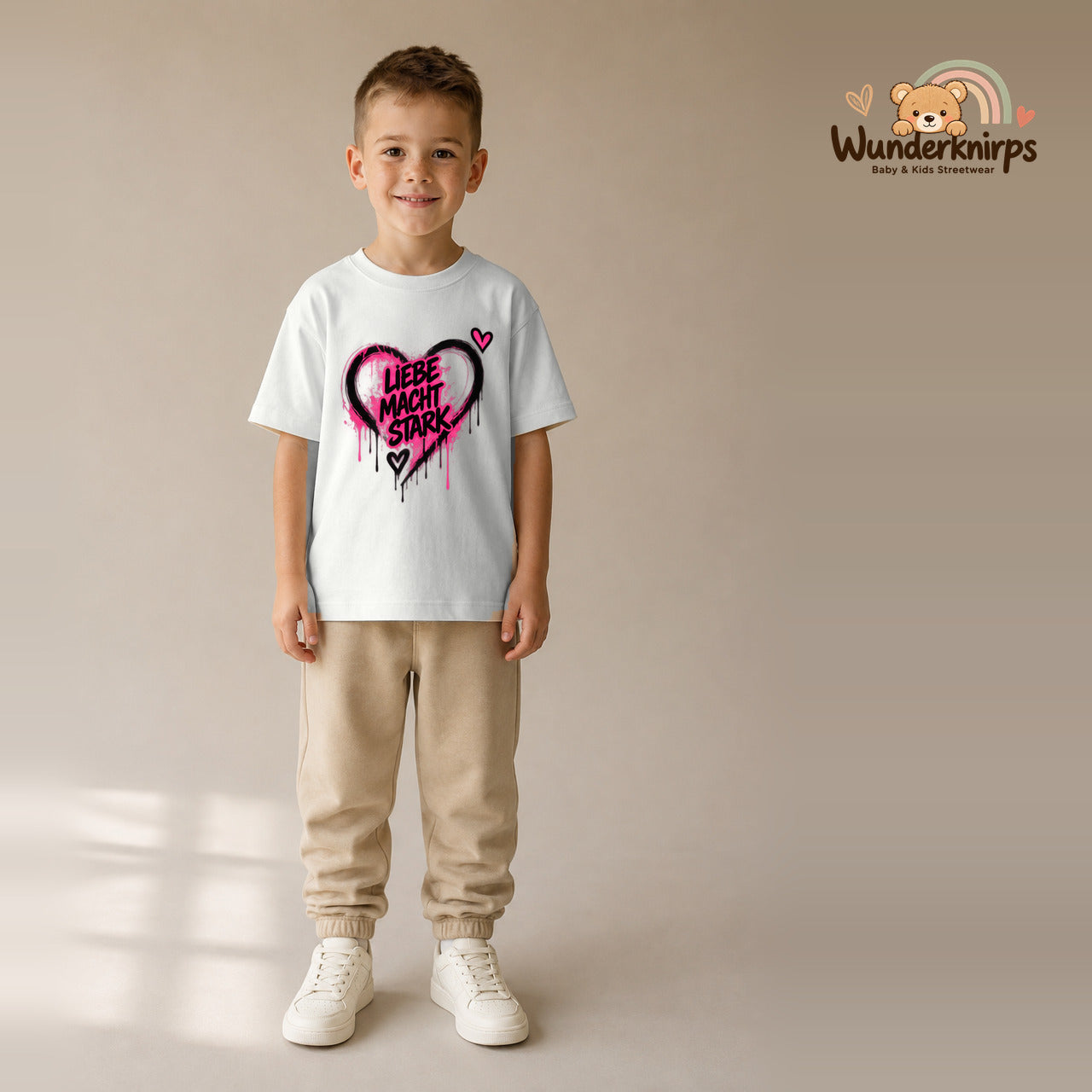 T-Shirt für Jungen in Weiß mit Motiv „Liebe macht stark“, getragen von einem Kind – Wunderknirps.