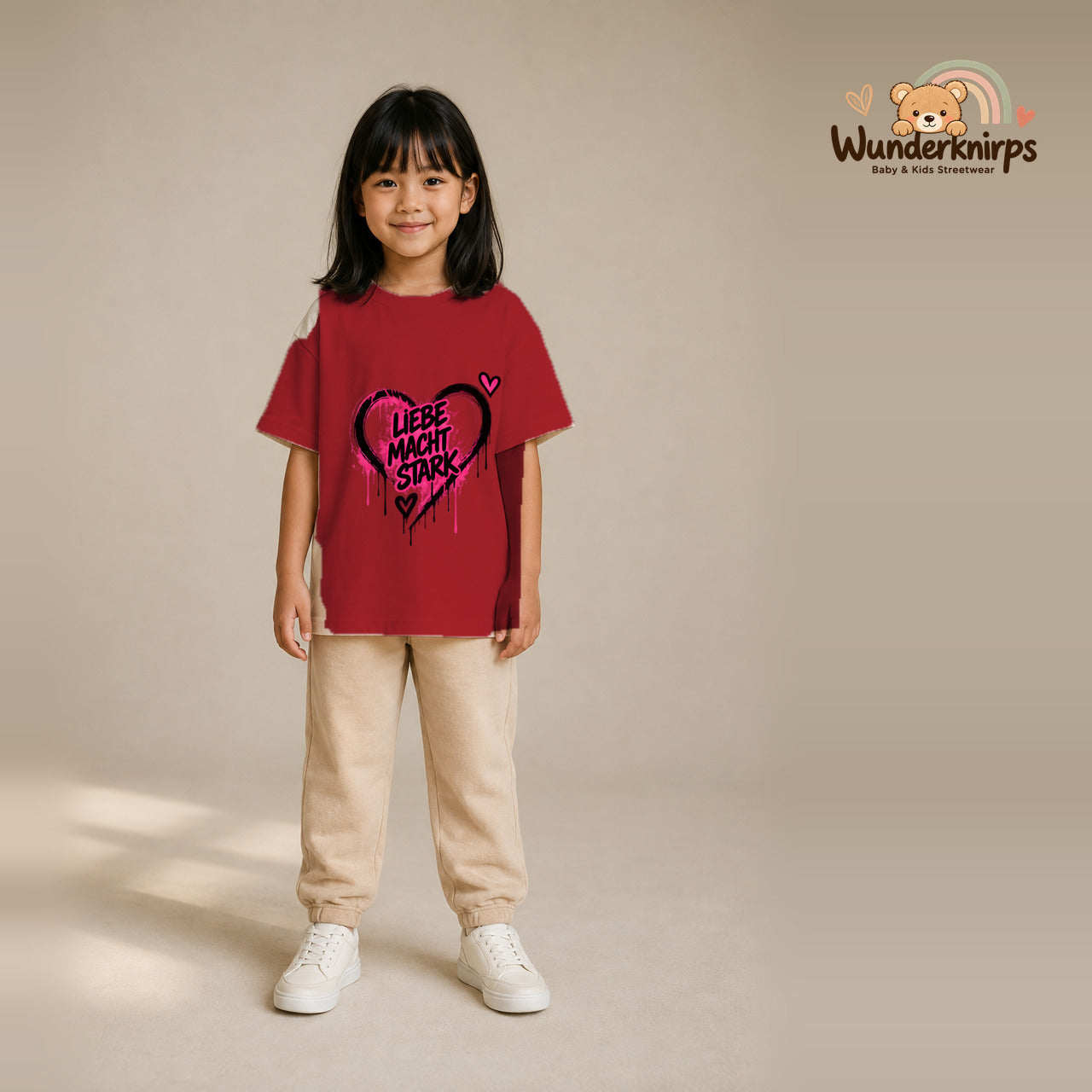T-Shirt für Mädchen in Rot mit Motiv „Liebe macht stark“, getragen von einem Kind – Wunderknirps.