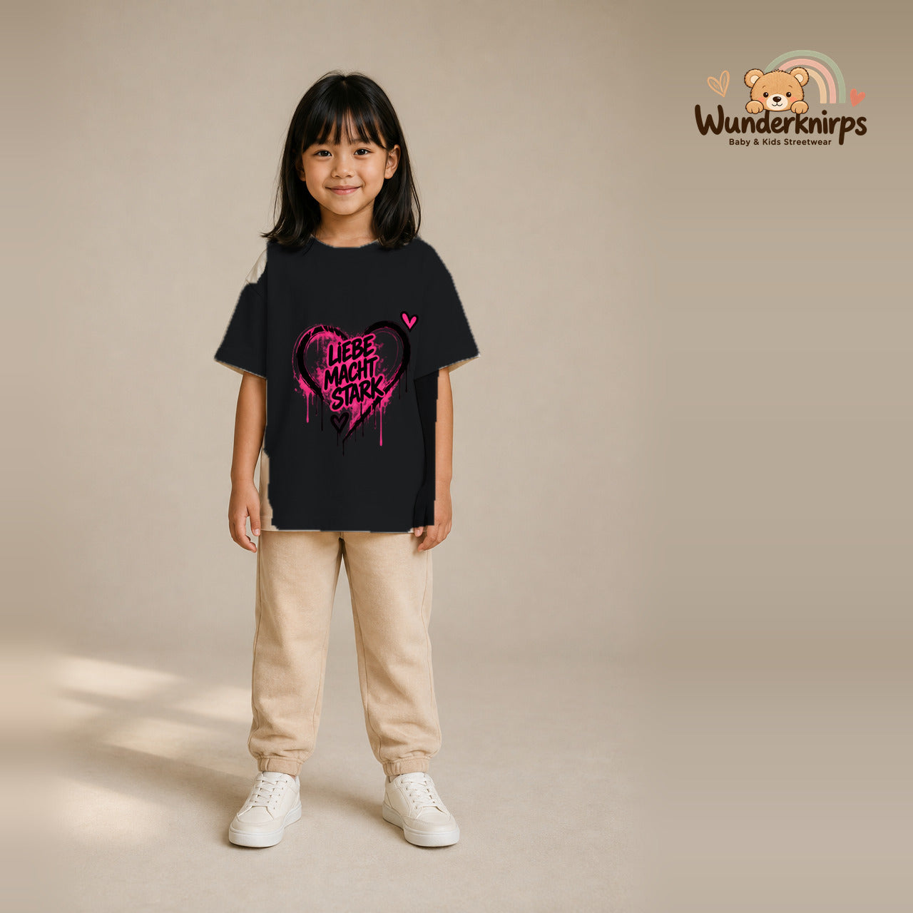 T-Shirt für Mädchen in Schwarz mit Motiv „Liebe macht stark“, getragen von einem Kind – Wunderknirps.