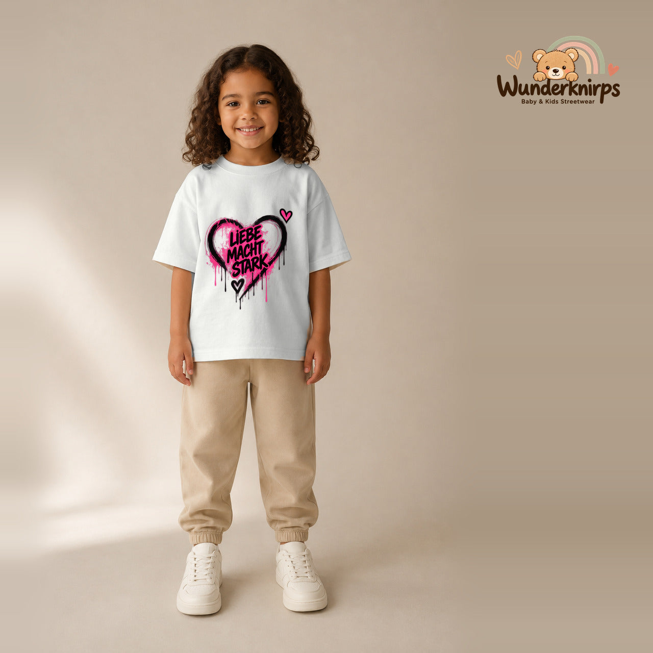T-Shirt für Mädchen in Weiß mit Motiv „Liebe macht stark“, getragen von einem Kind – Wunderknirps.