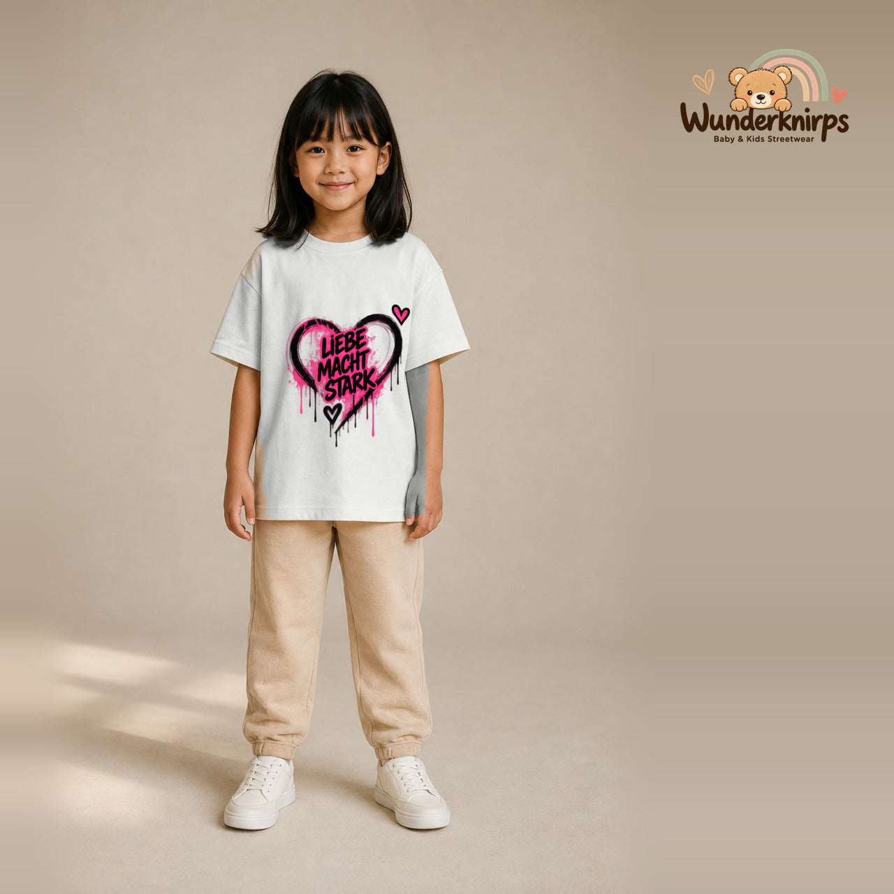 T-Shirt für Mädchen in Weiß mit Motiv „Liebe macht stark“, getragen von einem Kind – Wunderknirps.