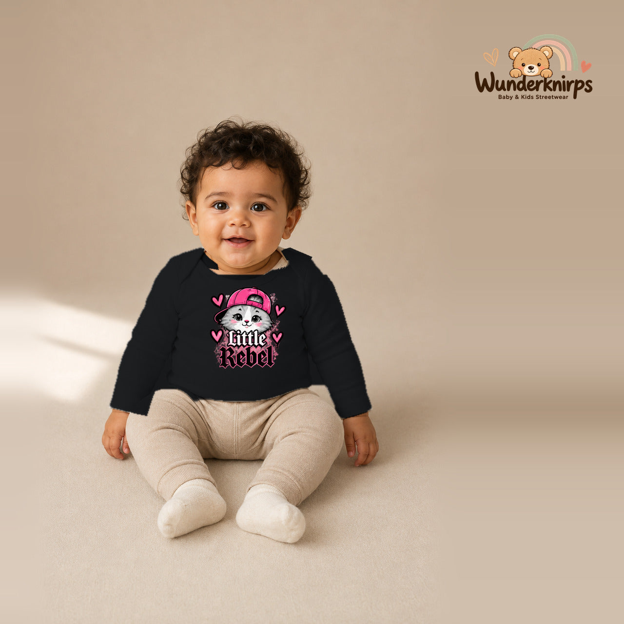 Babybody für Jungen in Schwarz mit Motiv „Little Rebel“, getragen von einem Kind – Wunderknirps.