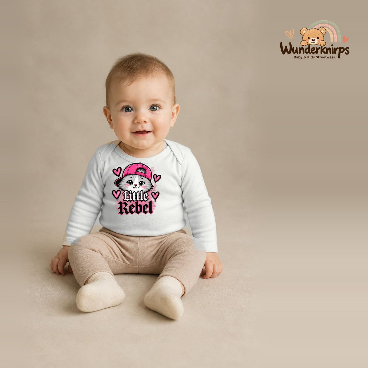 Babybody für Jungen in Weiß mit Motiv „Little Rebel“, getragen von einem Kind – Wunderknirps.