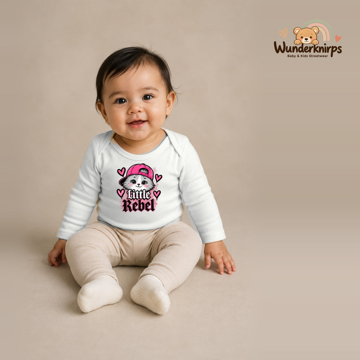 Babybody für Mädchen in Weiß mit Motiv „Little Rebel“, getragen von einem Kind – Wunderknirps.