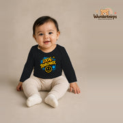 Babybody für Mädchen in Schwarz mit Motiv „Local Troublemaker“, getragen von einem Kind – Wunderknirps.