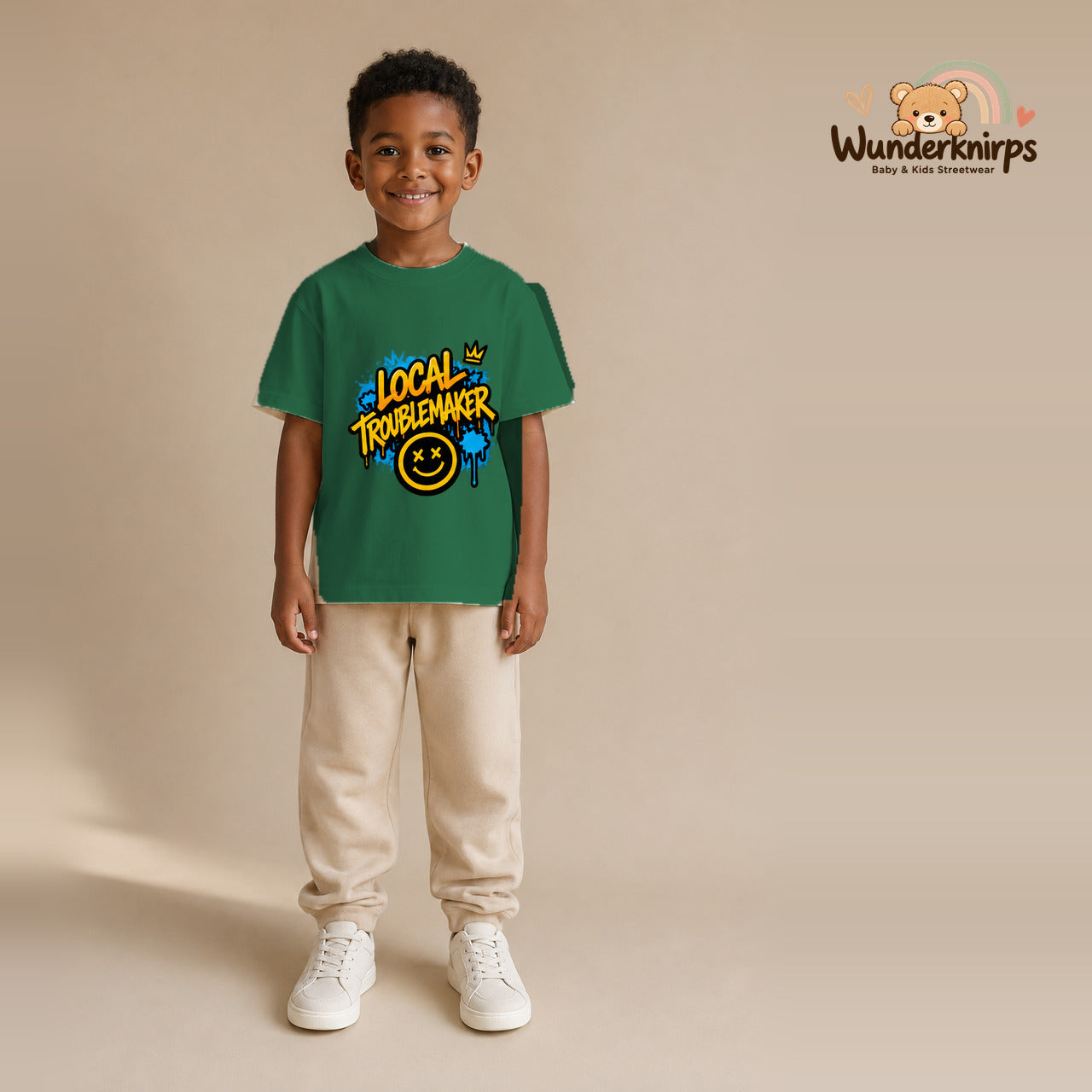 T-Shirt für Jungen in Grün mit Motiv „Local Troublemaker“, getragen von einem Kind – Wunderknirps.