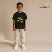 T-Shirt für Jungen in Schwarz mit Motiv „Local Troublemaker“, getragen von einem Kind – Wunderknirps.