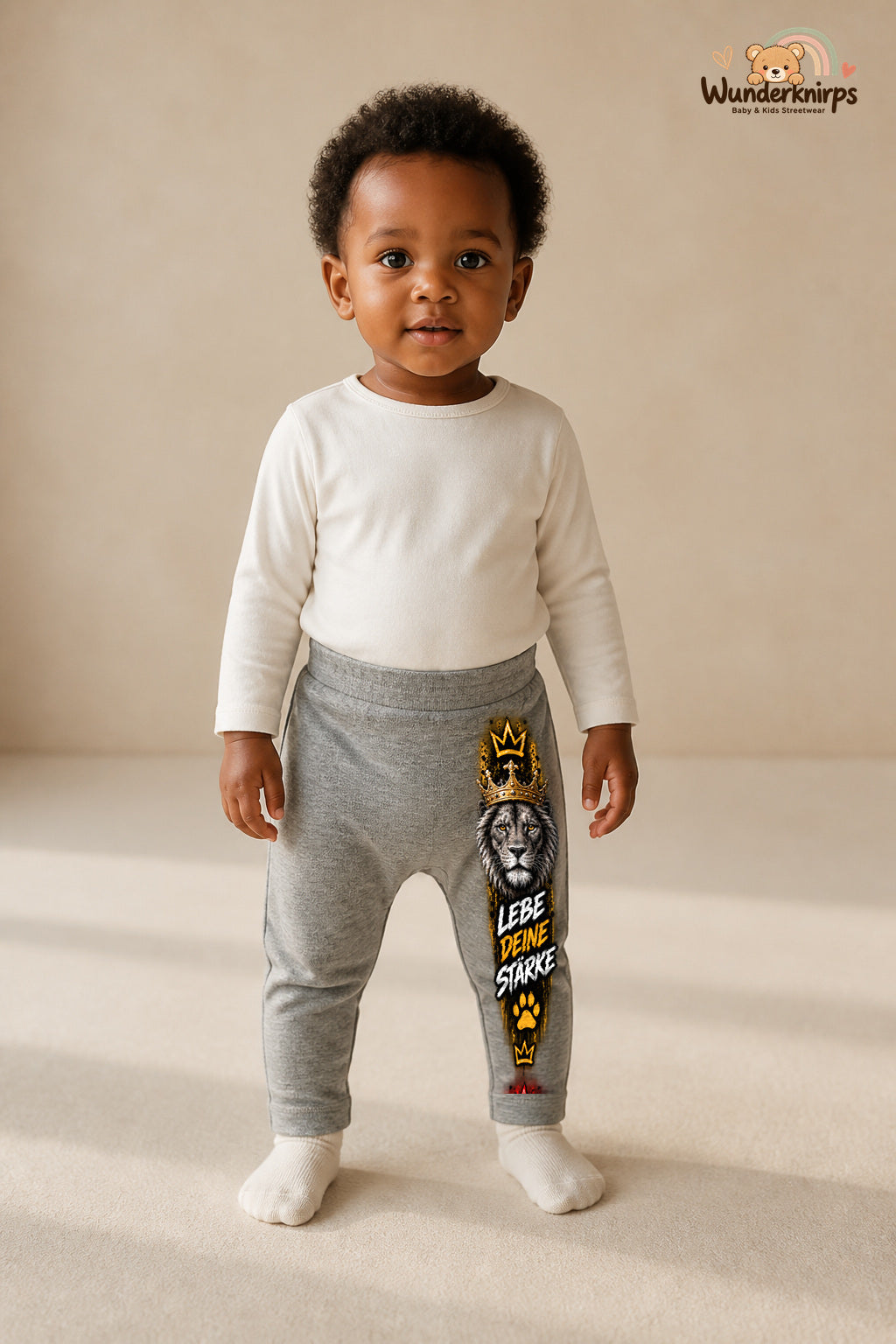 Kleine Weltentdeckerin: Lebe deine Stärke – Babyhose für Mädchen: Grau meliert mit Löwe-Druck am Hosenbein – Wunderknirps.