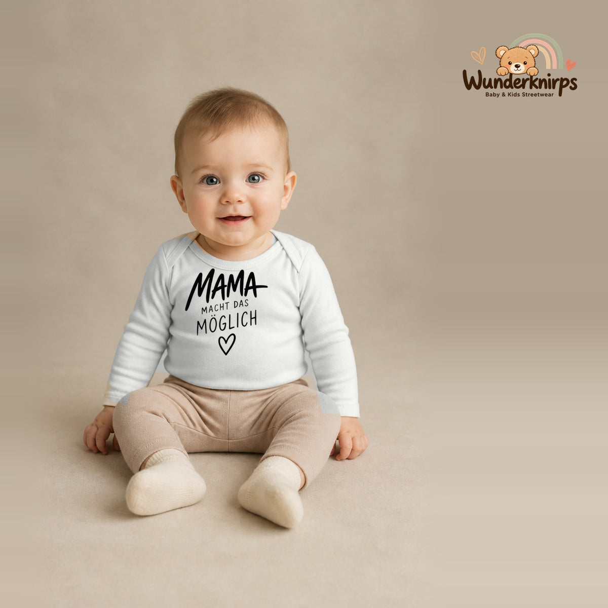 Babybody für Jungen in Weiß mit Motiv „Mama macht das möglich“, getragen von einem Kind – Wunderknirps.