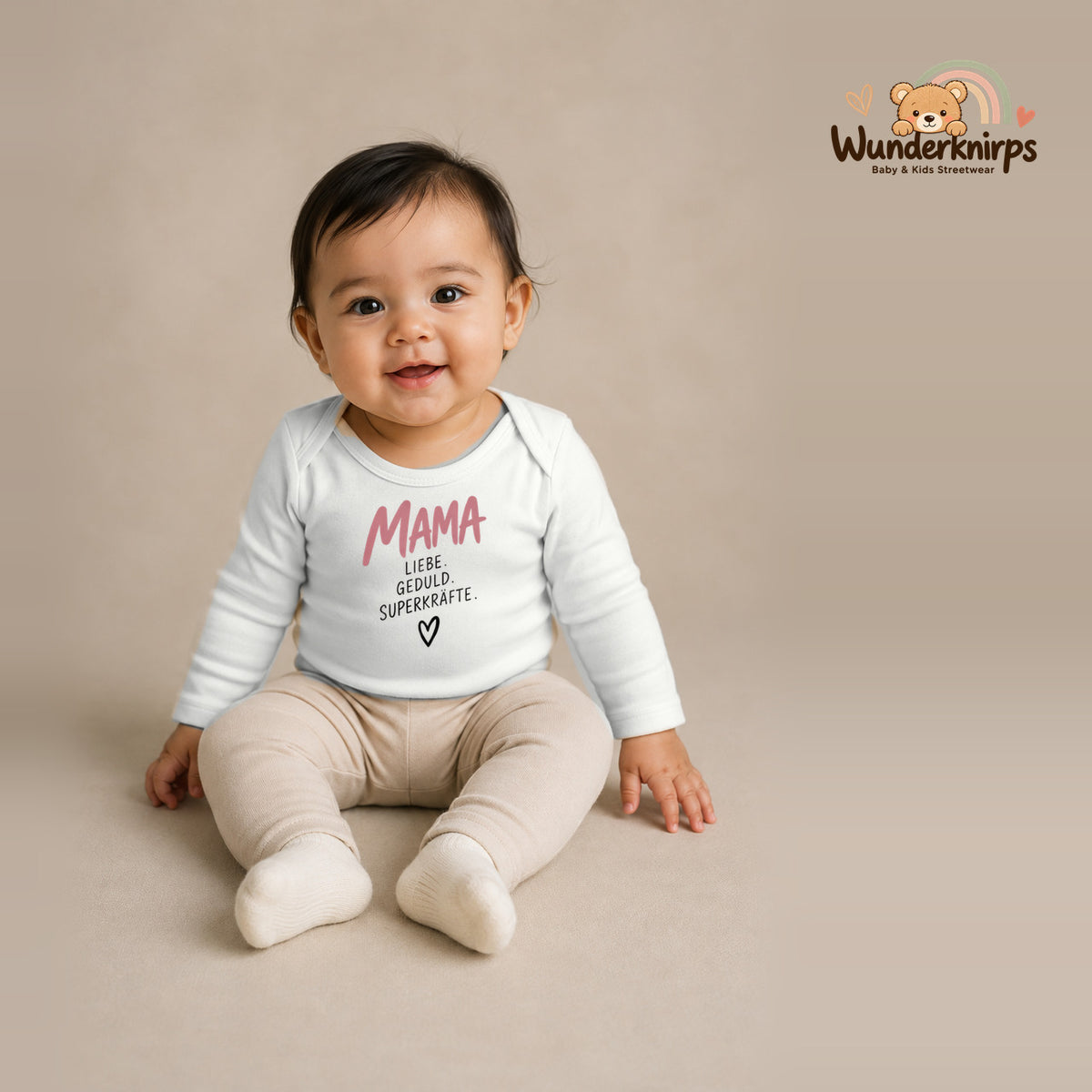 Babybody für Mädchen in Weiß mit Motiv „Mama Superkräfte“, getragen von einem Kind – Wunderknirps.