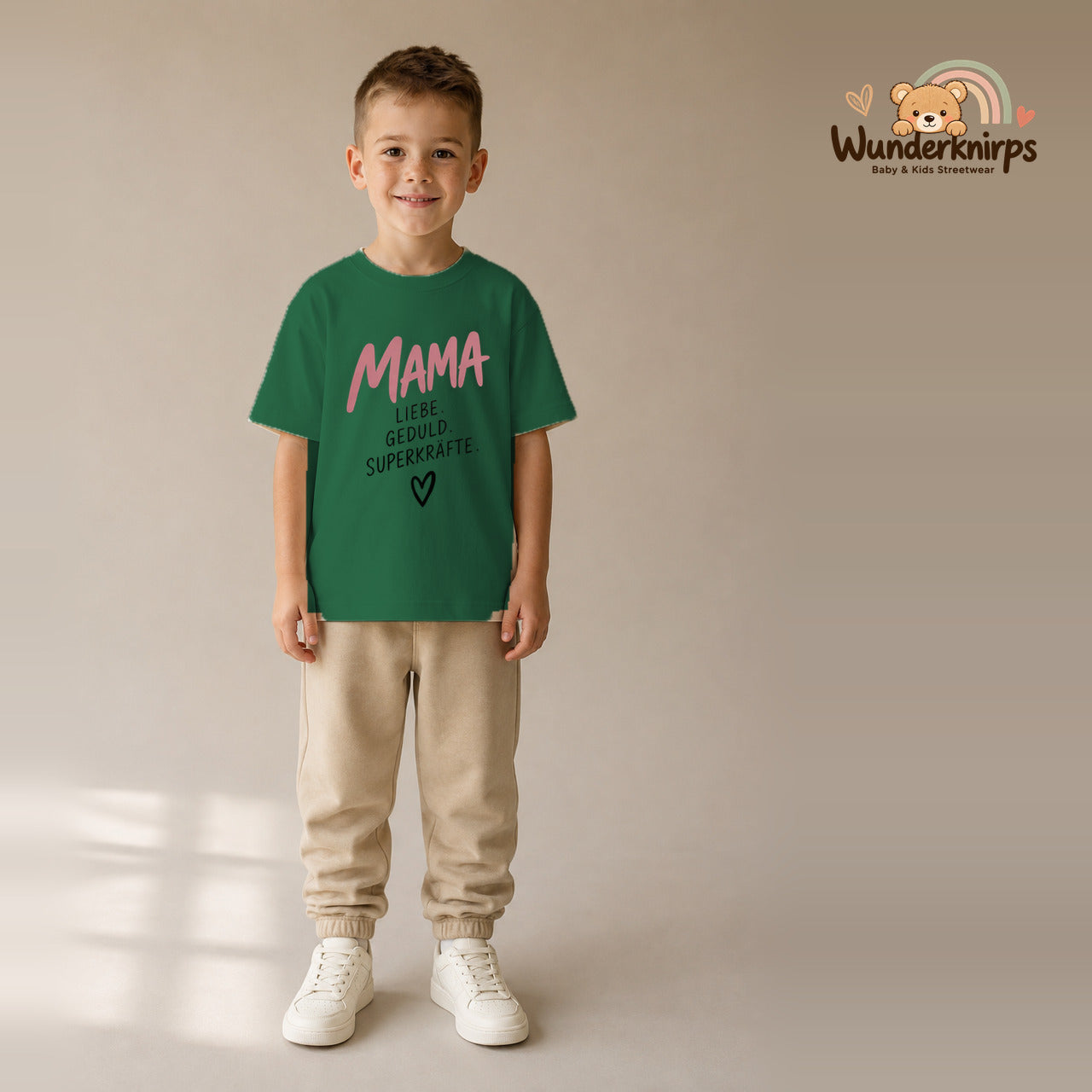 T-Shirt für Jungen in Grün mit Motiv „Mama Superkräfte“, getragen von einem Kind – Wunderknirps.