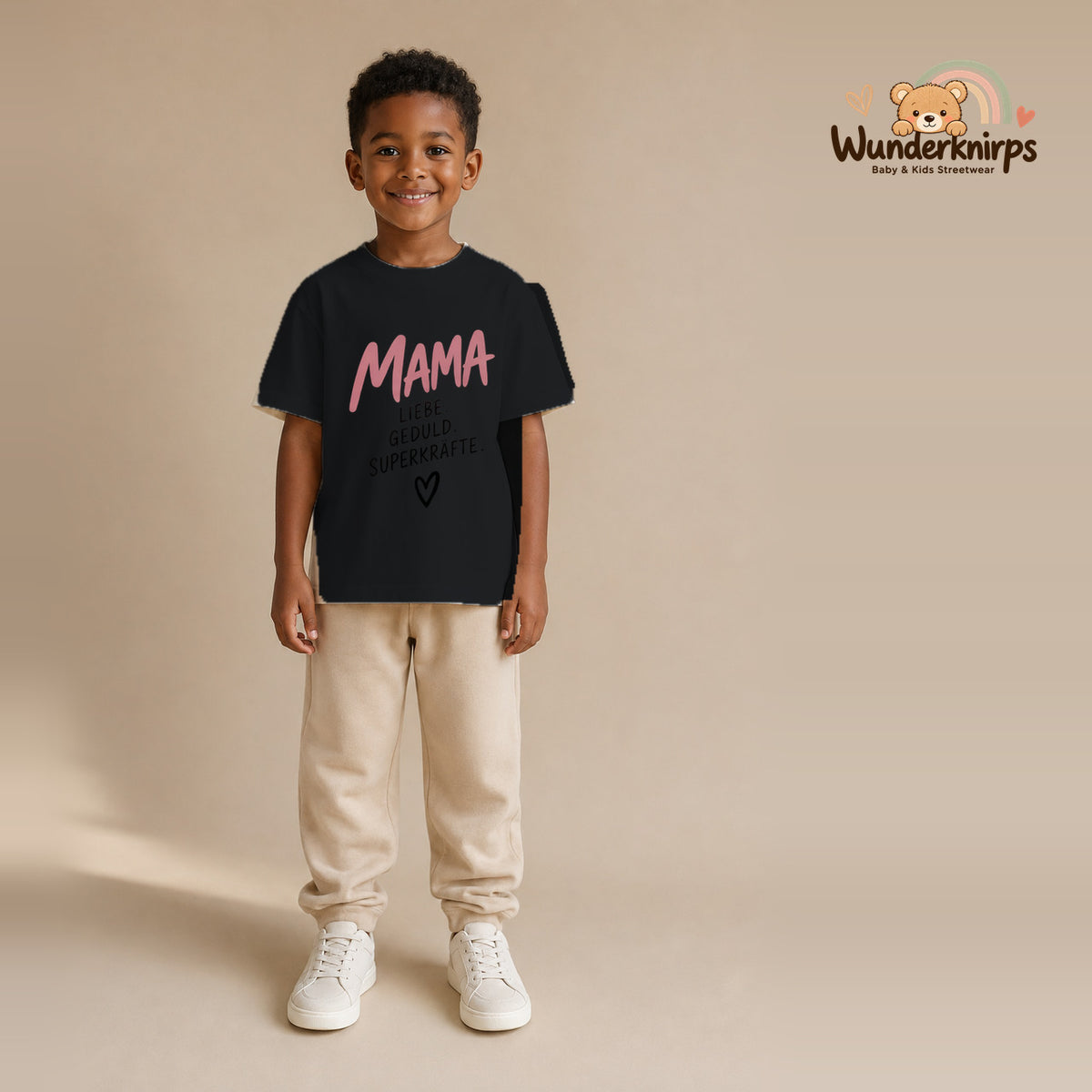 T-Shirt für Jungen in Schwarz mit Motiv „Mama Superkräfte“, getragen von einem Kind – Wunderknirps.