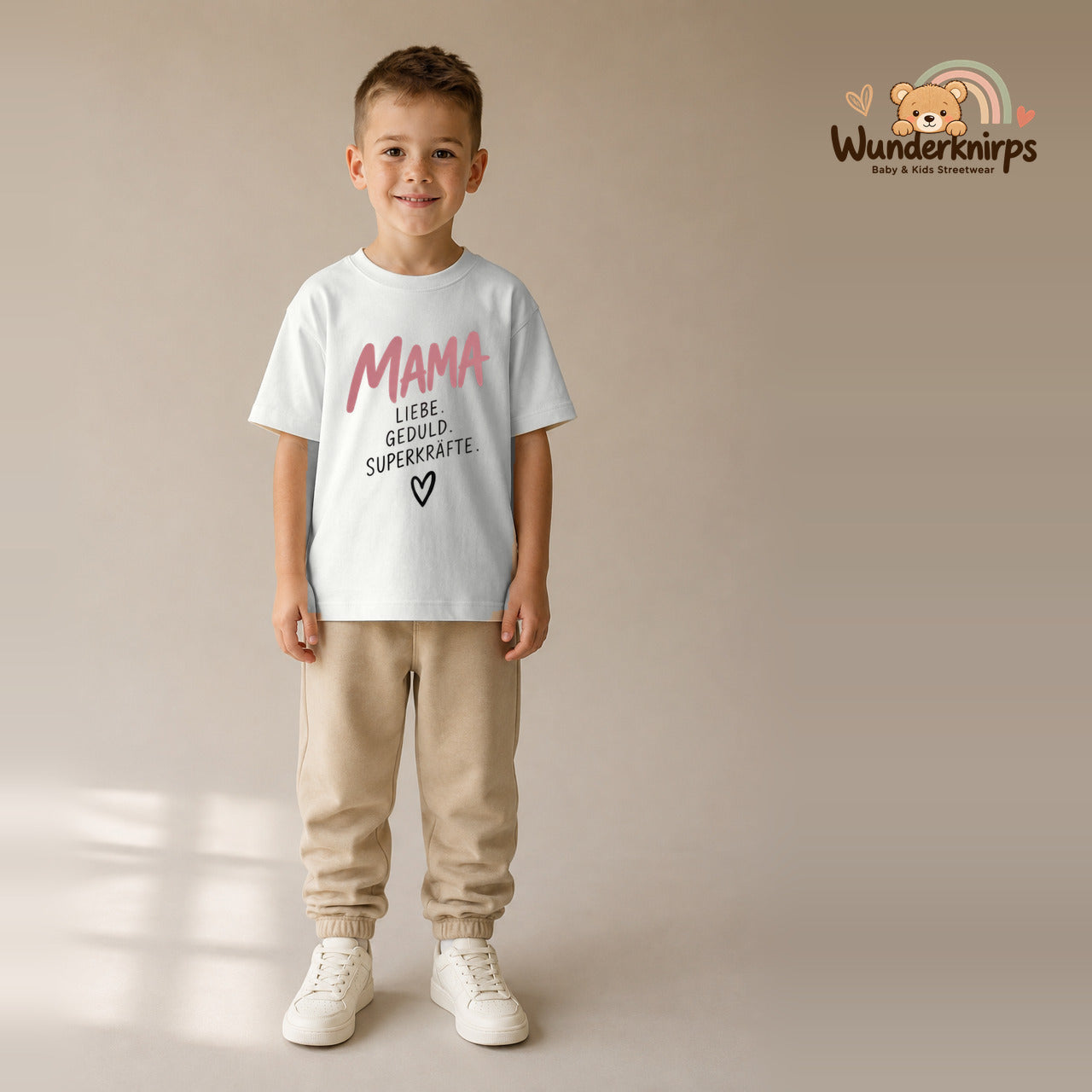 T-Shirt für Jungen in Weiß mit Motiv „Mama Superkräfte“, getragen von einem Kind – Wunderknirps.