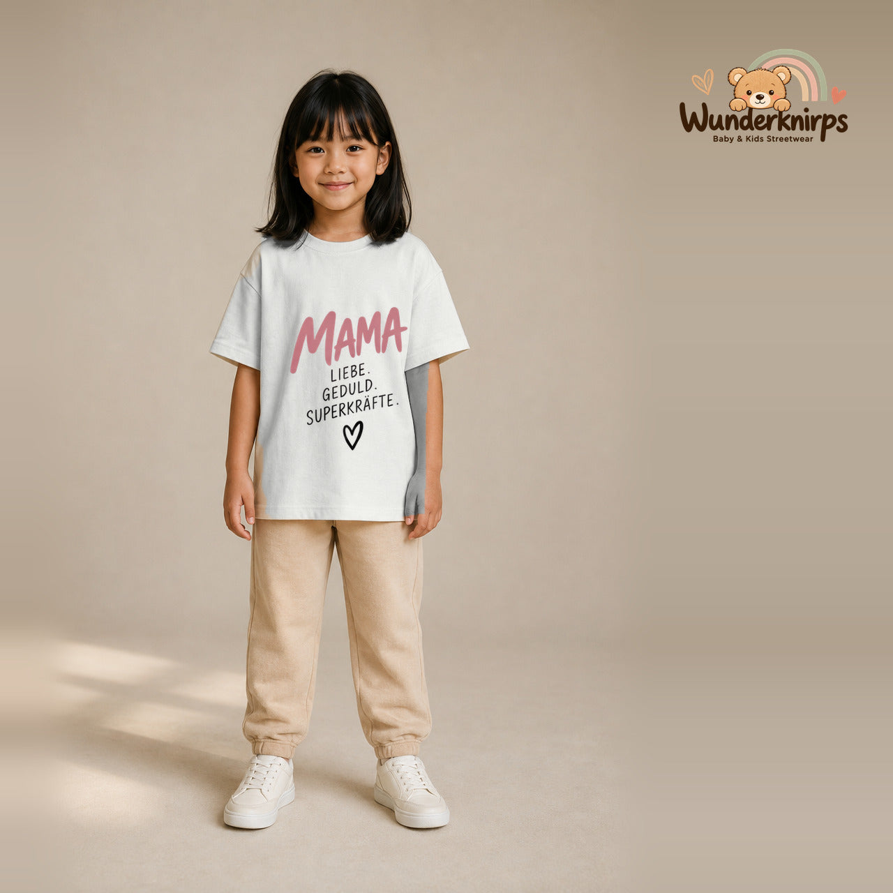 T-Shirt für Mädchen in Weiß mit Motiv „Mama Superkräfte“, getragen von einem Kind – Wunderknirps.