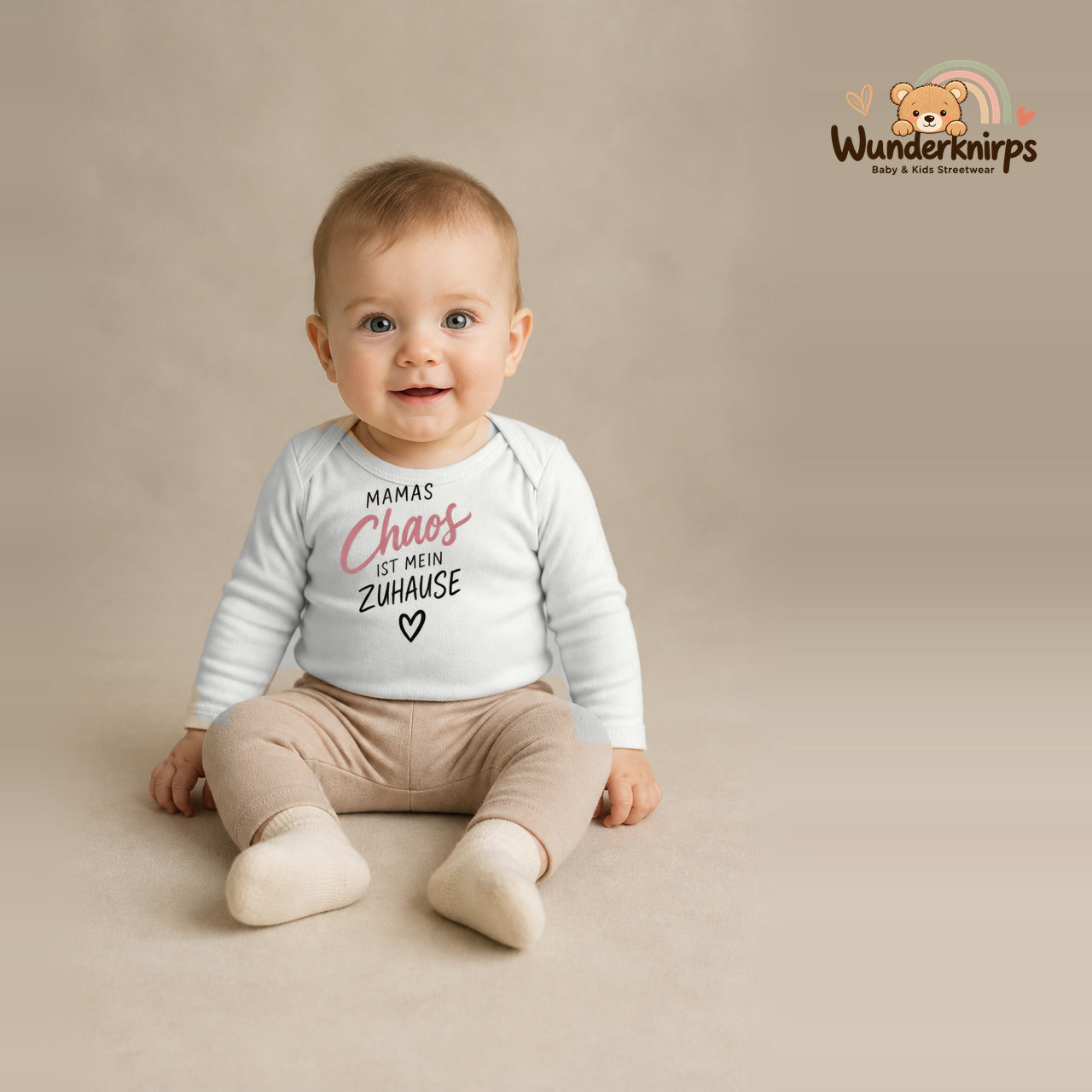 Babybody für Jungen in Weiß mit Motiv „Mamas Chaos“, getragen von einem Kind – Wunderknirps.