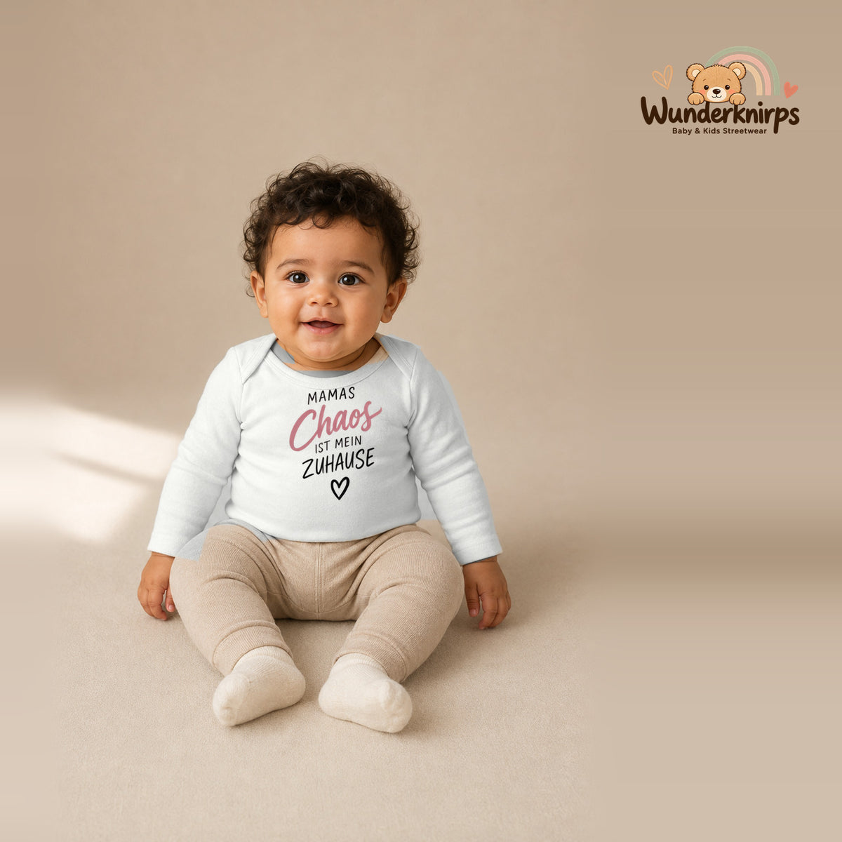 Babybody für Jungen in Weiß mit Motiv „Mamas Chaos“, getragen von einem Kind – Wunderknirps.