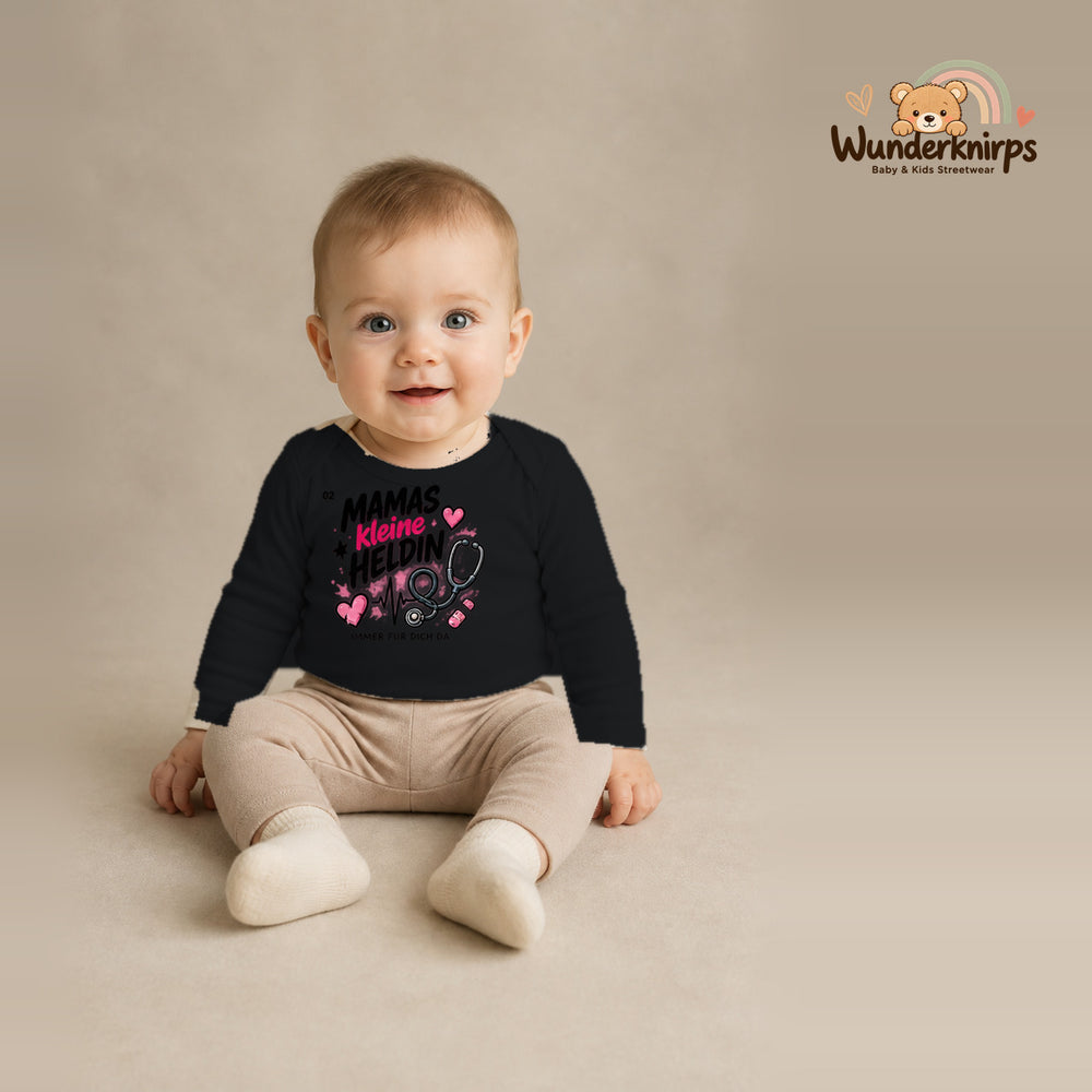 Babybody für Jungen in Schwarz mit Motiv „Mamas kleine Heldin“, getragen von einem Kind – Wunderknirps.