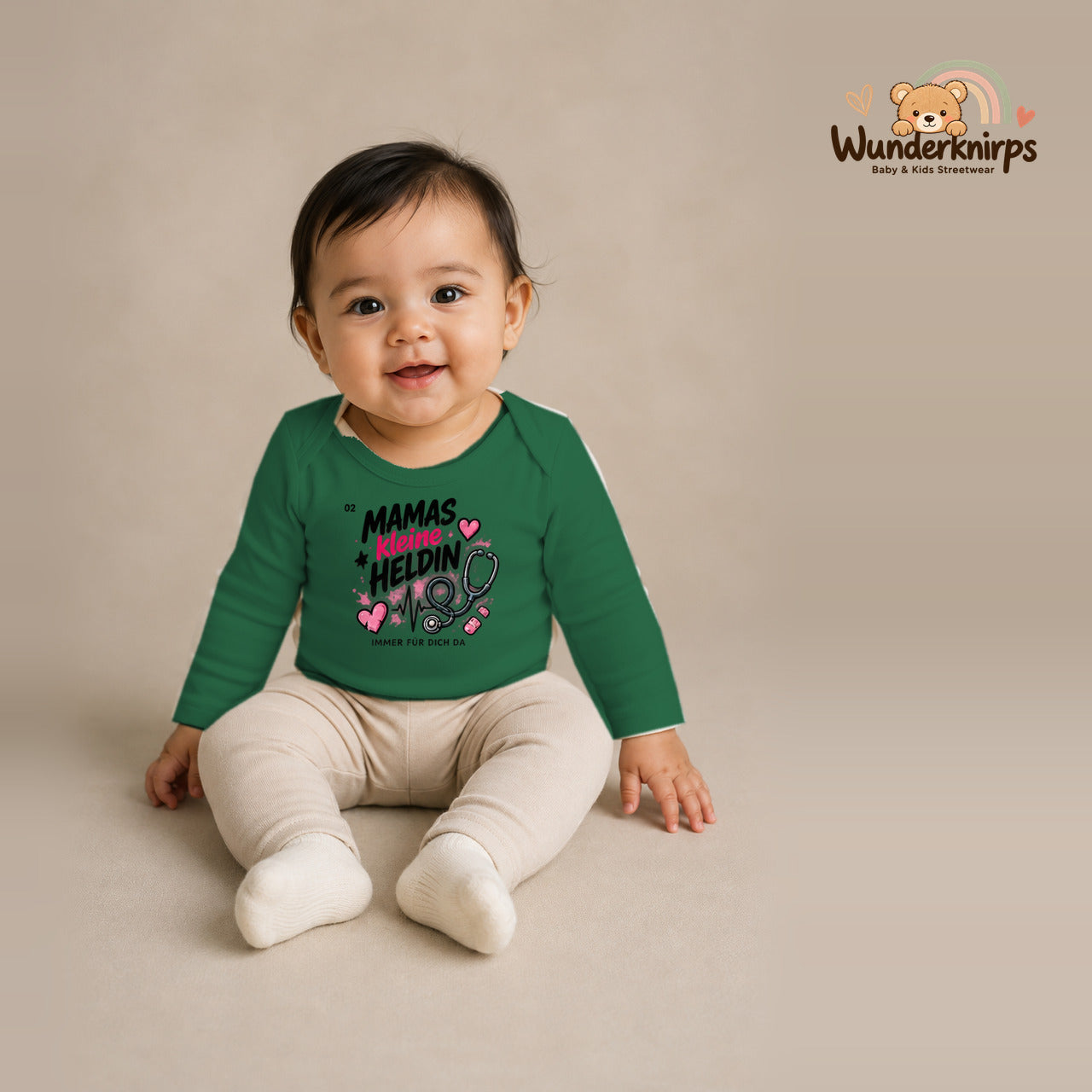 Babybody für Mädchen in Grün mit Motiv „Mamas kleine Heldin“, getragen von einem Kind – Wunderknirps.