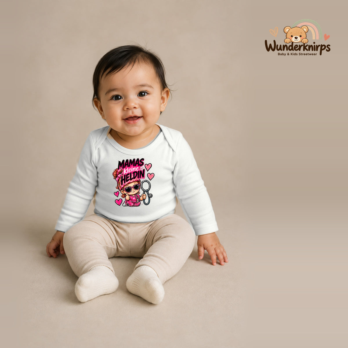 Babybody für Mädchen in Weiß mit Motiv „Mamas kleine Heldin“, getragen von einem Kind – Wunderknirps.