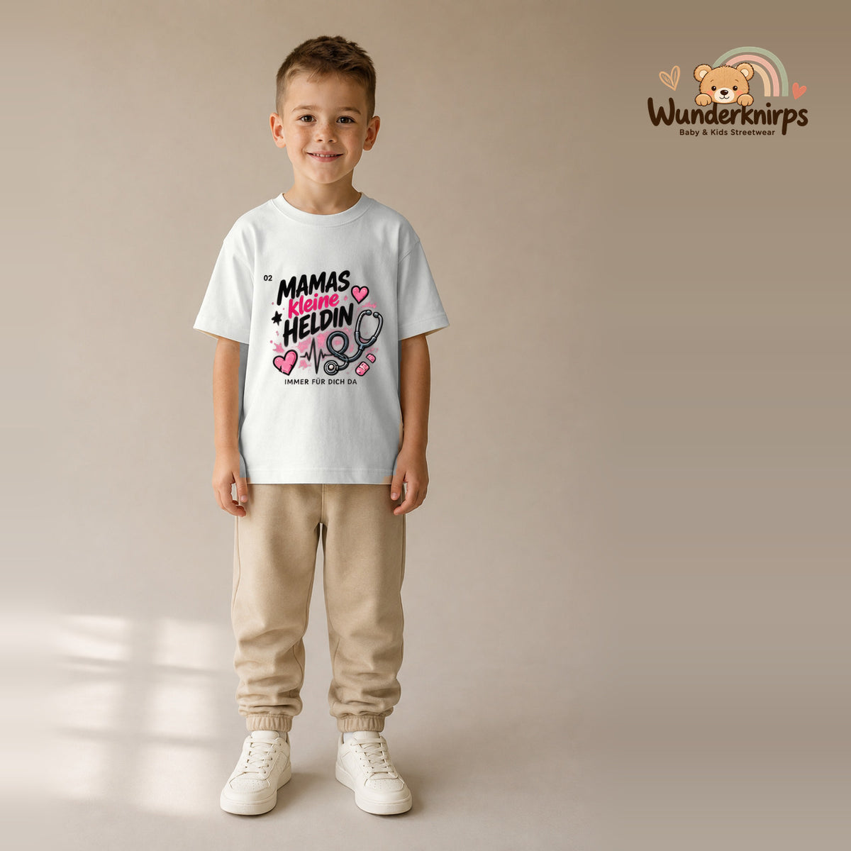T-Shirt für Jungen in Weiß mit Motiv „Mamas kleine Heldin“, getragen von einem Kind – Wunderknirps.